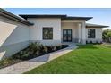 A landscaped walkway leads to the front door of this modern one-story home, complemented by fresh plantings at 14207 Fort Worth Cir, Port Charlotte, FL 33981