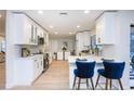 Contemporary white kitchen with stainless steel appliances and breakfast bar seating at 15002 Winterwind Dr, Tampa, FL 33624