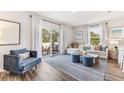 Sunlit living room boasts contemporary furnishings, plush seating, and sliding glass doors to an outdoor patio at 17445 Haysack Ter, Lakewood Ranch, FL 34211