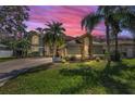 Charming two-story home with lush lawn and manicured landscaping under an early evening pink sky at 2075 Warwick Dr, Oldsmar, FL 34677