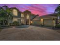 Exterior view of the home showcasing the large three-car garage and inviting front entrance with a stone facade at 2075 Warwick Dr, Oldsmar, FL 34677