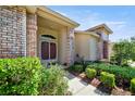 Inviting home entrance featuring brick columns, arched window, and well-manicured landscaping at 2348 Rolling View Dr, Spring Hill, FL 34606
