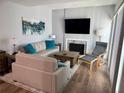Stylish living room featuring neutral sofas, a large TV, and an elegant fireplace at 247 Rex Pl # G, Madeira Beach, FL 33708