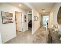 Bright hallway with neutral walls, tile flooring, and decorative accents leading to various rooms at 3251 Silver Date Dr, Wimauma, FL 33598