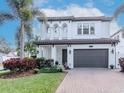 Elegant two-story home with arched windows, lush landscaping, and a brick driveway at 4302 W San Pedro St, Tampa, FL 33629