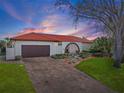 Charming home featuring a red tile roof, landscaped yard, brick-paved driveway and attached garage at 4901 Lansing St Ne, St Petersburg, FL 33703