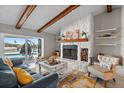 Cozy living room featuring a stone fireplace, wood beam ceiling, and views of the canal at 4901 Lansing St Ne, St Petersburg, FL 33703