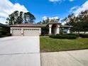 Charming single-story home featuring a well-manicured lawn and a spacious three-car garage at 9006 Callaway Dr, Trinity, FL 34655