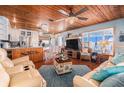 Open-concept living area with wood ceilings, a large TV, and seamless flow to the kitchen, ideal for modern living at 9920 Alavista Dr, Gibsonton, FL 33534