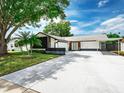 Charming single Gathering home with a well-maintained lawn, lush trees and extended driveway at 10064 82Nd St, Seminole, FL 33777