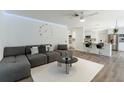 Comfortable living room featuring modern decor, a ceiling fan, and seamless flow into the kitchen at 10064 82Nd St, Seminole, FL 33777