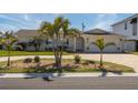 Charming home featuring a well-manicured lawn, brick driveway, and mature palm trees at 102 23Rd St, Belleair Beach, FL 33786