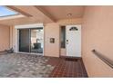 Inviting porch with a patterned brick floor, sliding glass doors, and a white front door at 10467 Larchmont N Pl, Pinellas Park, FL 33782