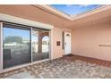 Covered front porch with brick pavers, white door, and sliding glass doors at 10467 Larchmont N Pl, Pinellas Park, FL 33782