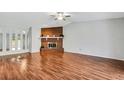 Spacious living room with vaulted ceiling, beautiful wood floors, and a cozy brick fireplace ready for your personal touch at 105 Lotus Cir, Safety Harbor, FL 34695