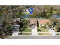 Aerial view of a lakeside home with a well-maintained yard, mature trees, and a serene waterfront setting at 1731 Elk Spring Dr, Brandon, FL 33511