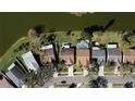 An aerial view showcases a neighborhood with a mix of homes, some featuring pools, nestled along a scenic lake at 1731 Elk Spring Dr, Brandon, FL 33511