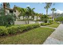 Well-maintained condo building with lush greenery and mature palm trees at 1800 Mariner Dr # 9, Tarpon Springs, FL 34689