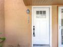 Close-up of the exterior front door with glass panels and a security system at 1884 Clearbrooke Dr # 1884, Clearwater, FL 33760