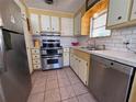 Efficient kitchen with stainless steel appliances and white and yellow cabinets at 2331 Belleair Rd # 527, Clearwater, FL 33764