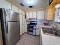 Well-lit kitchen featuring stainless steel appliances and tiled floors at 2331 Belleair Rd # 527, Clearwater, FL 33764