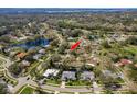 Aerial view of a neighborhood with mature trees, community pond, and homes with private pools at 3321 Pattie Pl, Palm Harbor, FL 34685