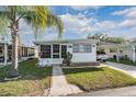 Inviting single-story home with bright facade, carport, and landscaped front yard at 37042 Lois Ave, Zephyrhills, FL 33542