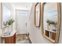 Inviting foyer with decorative mirrors, light wood floors, console table, and stylish decor at 4117 Goldheart Blvd, Bradenton, FL 34208