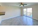 Bright living room features tile flooring, fan, and sliding glass doors to the balcony at 5820 N Church Ave # 430, Tampa, FL 33614