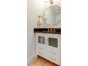 Elegant powder room with decorative mirror, gold fixtures, vanity and dark countertop at 6290 Bahia Del Mar Cir # 5, St Petersburg, FL 33715