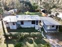 Charming home with a metal roof, landscaped yard, fenced backyard, and covered parking at 7043 Lang St, Brooksville, FL 34601