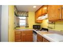 Efficient kitchen featuring wood cabinetry, gas range, and neutral countertops at 7043 Lang St, Brooksville, FL 34601