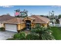 Two-car garage home with well-landscaped front yard, decorative elements, and an American flag at 127 Jennifer Dr, Rotonda West, FL 33947