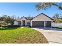 Charming single Gathering home with a well-manicured lawn, grey trim, and a 2-car garage at 1301 Jen Ma Jo Ln, Lutz, FL 33549