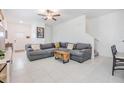 Spacious living room featuring tile floors, a gray sofa, and neutral walls at 21404 Darter Rd, Land O Lakes, FL 34638