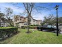 A charming two-story townhouse with lush landscaping, a green lawn, and a black pickup truck parked nearby at 2180 Clover Hill Rd, Palm Harbor, FL 34683