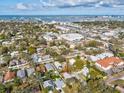 Aerial view of the neighborhood with blue skies, surrounding trees, and water views at 2530 Sunset Dr, Largo, FL 33770