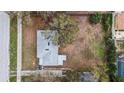 Birds eye view of single story home with grey roof surrounded by mature trees and large backyard with white picket fence at 2832 W Bay Haven Dr, Tampa, FL 33611