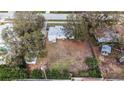 Single story home with large empty lot surrounded by mature trees in a residential neighborhood in aerial view at 2832 W Bay Haven Dr, Tampa, FL 33611