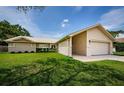 Side view of the charming home with a well-maintained lawn and attractive landscaping at 3350 Brian N Rd, Palm Harbor, FL 34685
