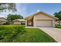 Inviting front exterior with a well-kept lawn and a welcoming entrance and front door at 3350 Brian N Rd, Palm Harbor, FL 34685