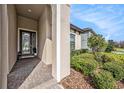 Inviting front porch with brick pavers, stylish front door, and manicured landscaping at 4016 Cadence Loop, Land O Lakes, FL 34638