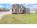 Charming two-story home with black shutters and a large, lush lawn with manicured landscaping at 4411 Miley Rd, Plant City, FL 33565