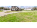 A beautiful two-story home with lush green lawn and a long driveway on a sunny day at 4411 Miley Rd, Plant City, FL 33565