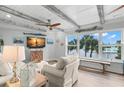 Bright living room featuring wood-beamed ceilings and a large window view overlooking the water at 4939 Floramar Ter # 208, New Port Richey, FL 34652