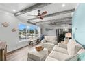 Open-concept living room showcases beamed ceilings, waterfront views, and cozy white furniture at 4939 Floramar Ter # 208, New Port Richey, FL 34652
