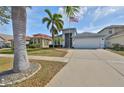 Charming home with well-maintained landscaping, palm trees, and an American flag at 5124 Clover Mist Dr, Apollo Beach, FL 33572