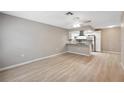 Spacious living room featuring light wood floors and adjoining kitchen at 6141 Chesham Dr # 7, New Port Richey, FL 34653