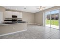 Open kitchen featuring black countertops, stainless steel appliances and access to the sliding glass doors to backyard at 7060 Woodchase Glen Dr, Riverview, FL 33578