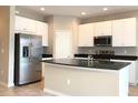 Bright kitchen featuring white cabinetry, stainless steel appliances, and a center island at 7060 Woodchase Glen Dr, Riverview, FL 33578